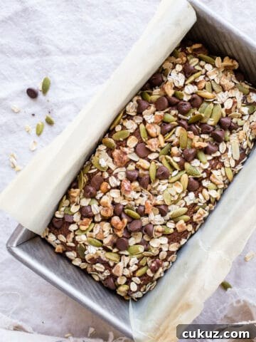 Quick bread with nuts and seeds in a loaf pan.