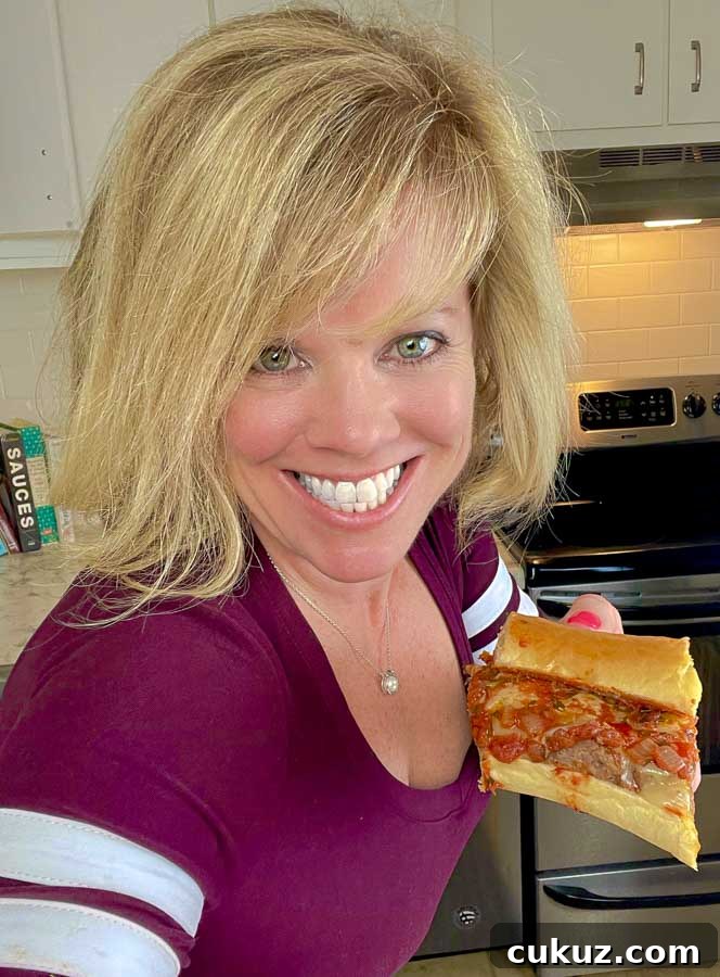 Jennifer holding a piece of the bomb Italian sausage sandwich