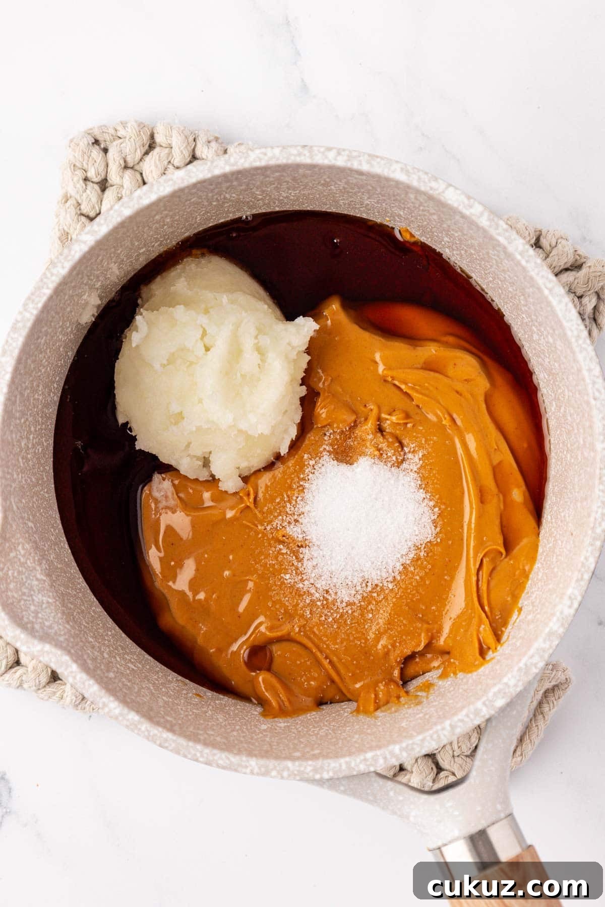 Peanut butter, maple syrup, coconut oil in saucepan