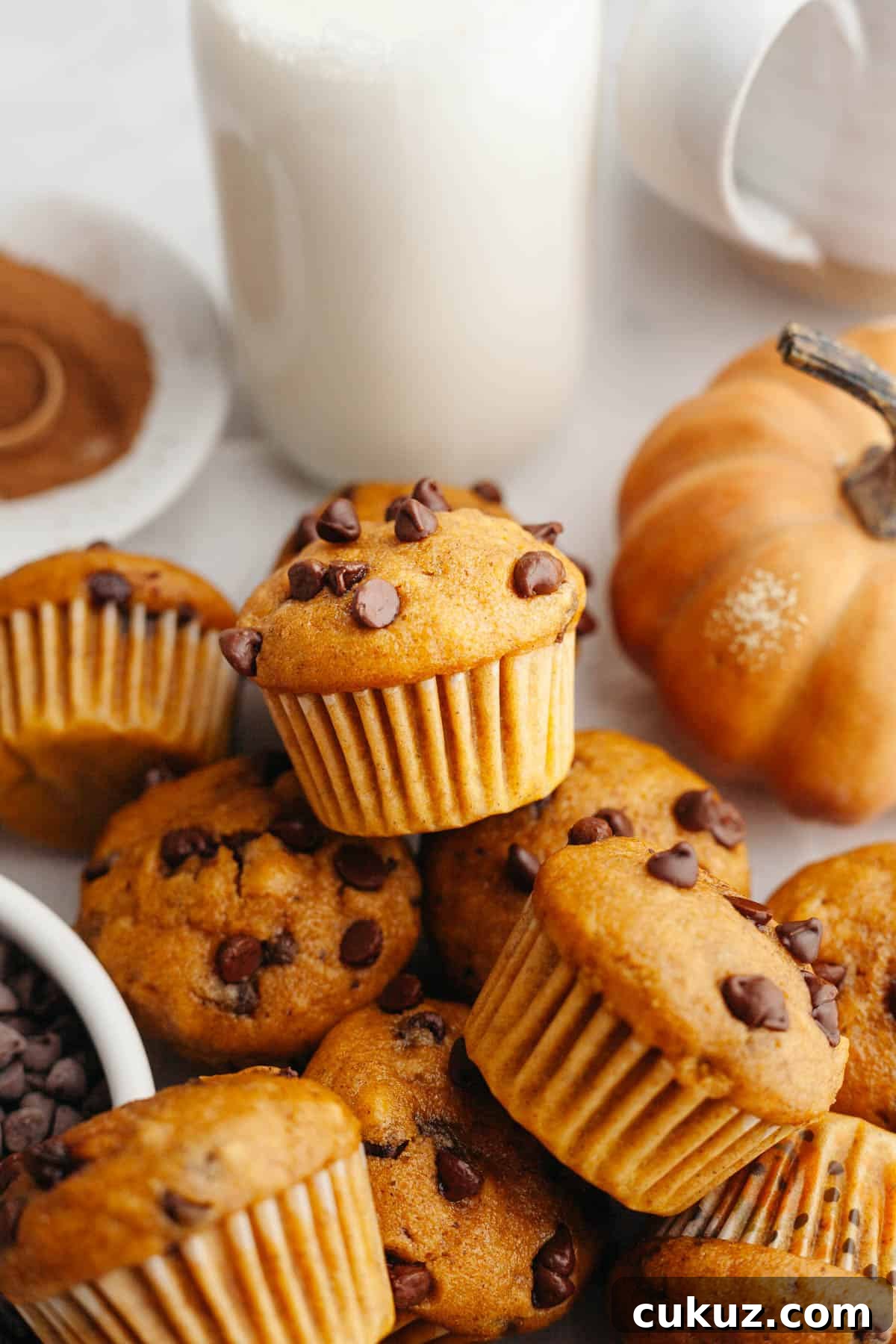A whole batch of mini pumpkin muffins with mini chocolate chips.