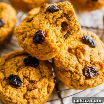 Sweet potato bran muffin with a bite taken out of it, on a wire rack with more sweet potato muffins