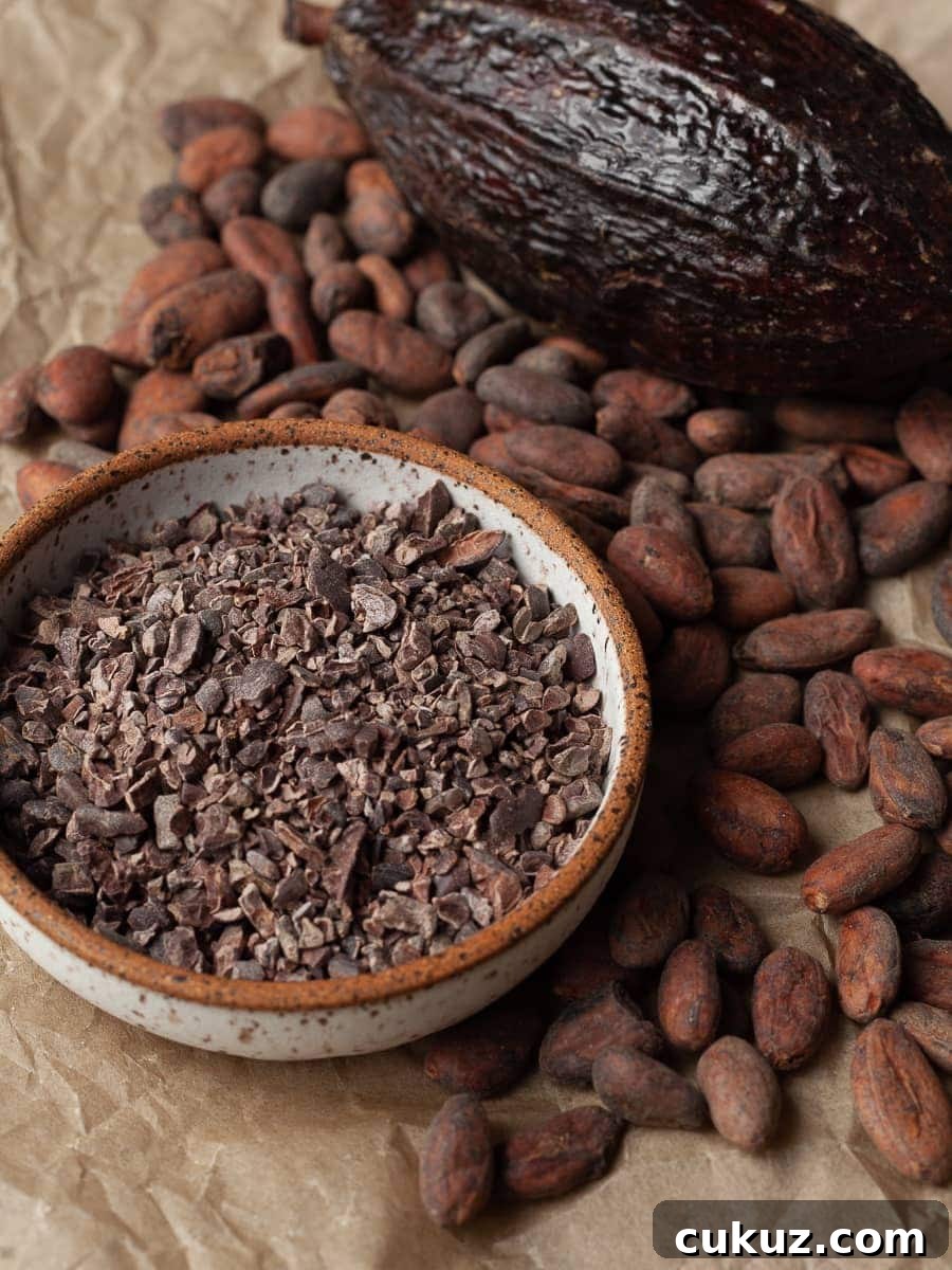 Raw cocoa nibs and cocoa beans on brown paper