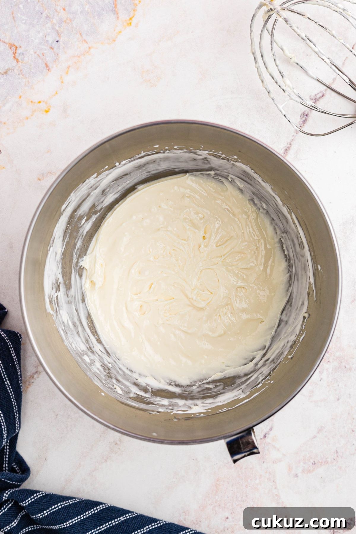 Smooth and creamy fruit dip after being mixed in a large silver bowl.