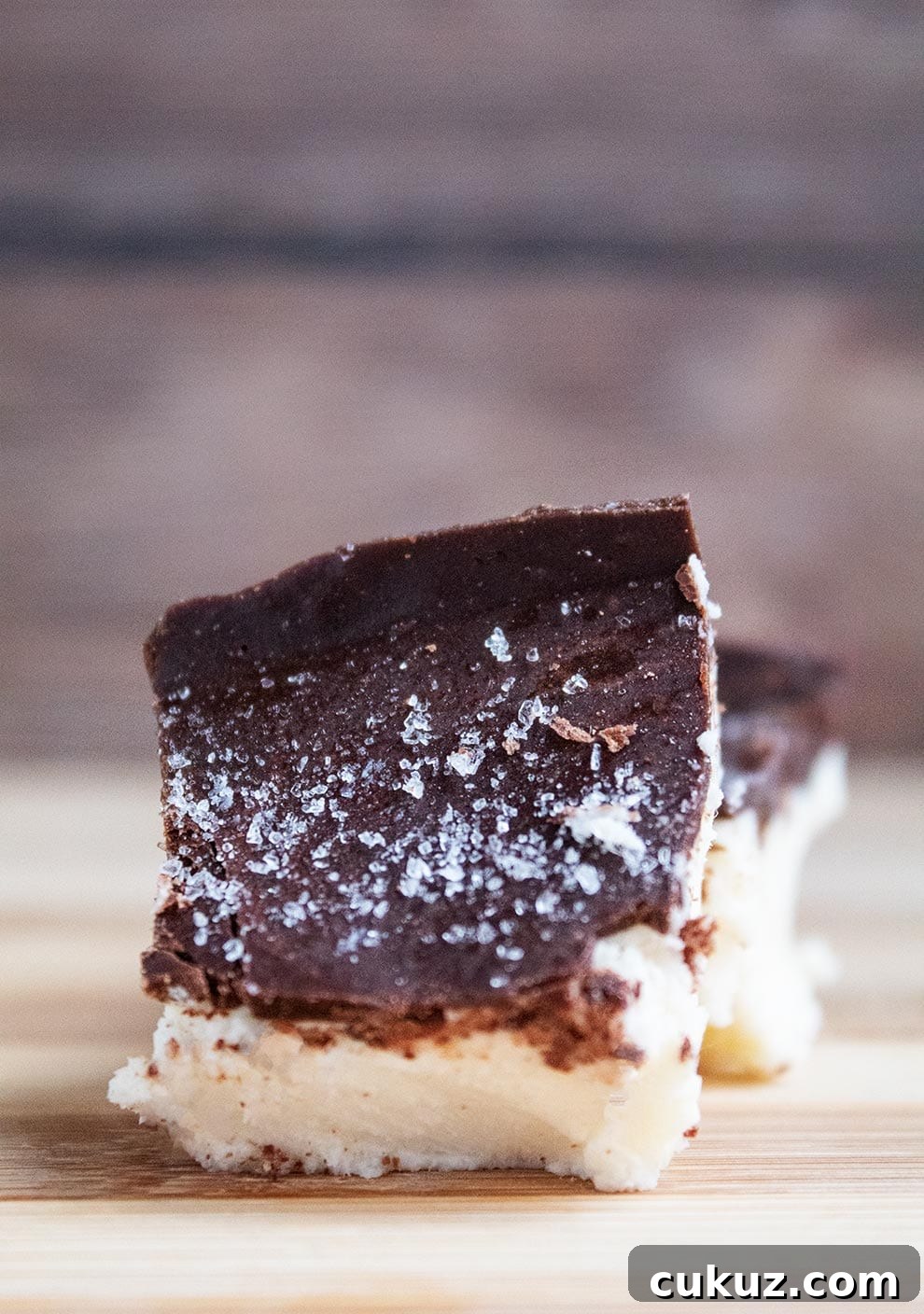 closeup of keto salted caramel fat bomb bar sitting on another one with salt on top