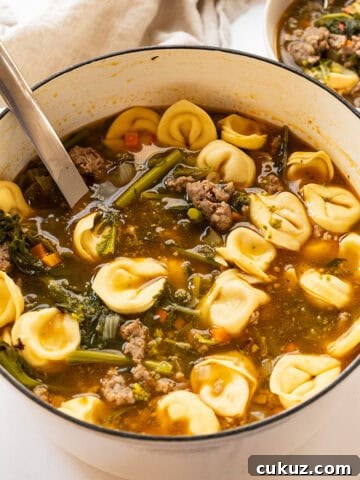 Sausage and broccoli rabe soup with tortellini in a dutch oven.